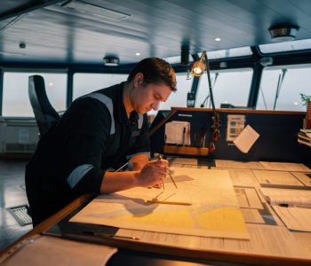 Marine navigational officer during navigational watch on bridge.